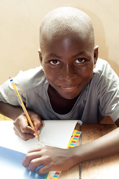 Yesu, a formerly trafficked girl practicing handwriting. photo by Gretchen Nickson.