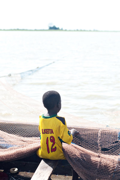 A young boy works on a fishing boat in Ghana, Africa. photo by Chris Field.